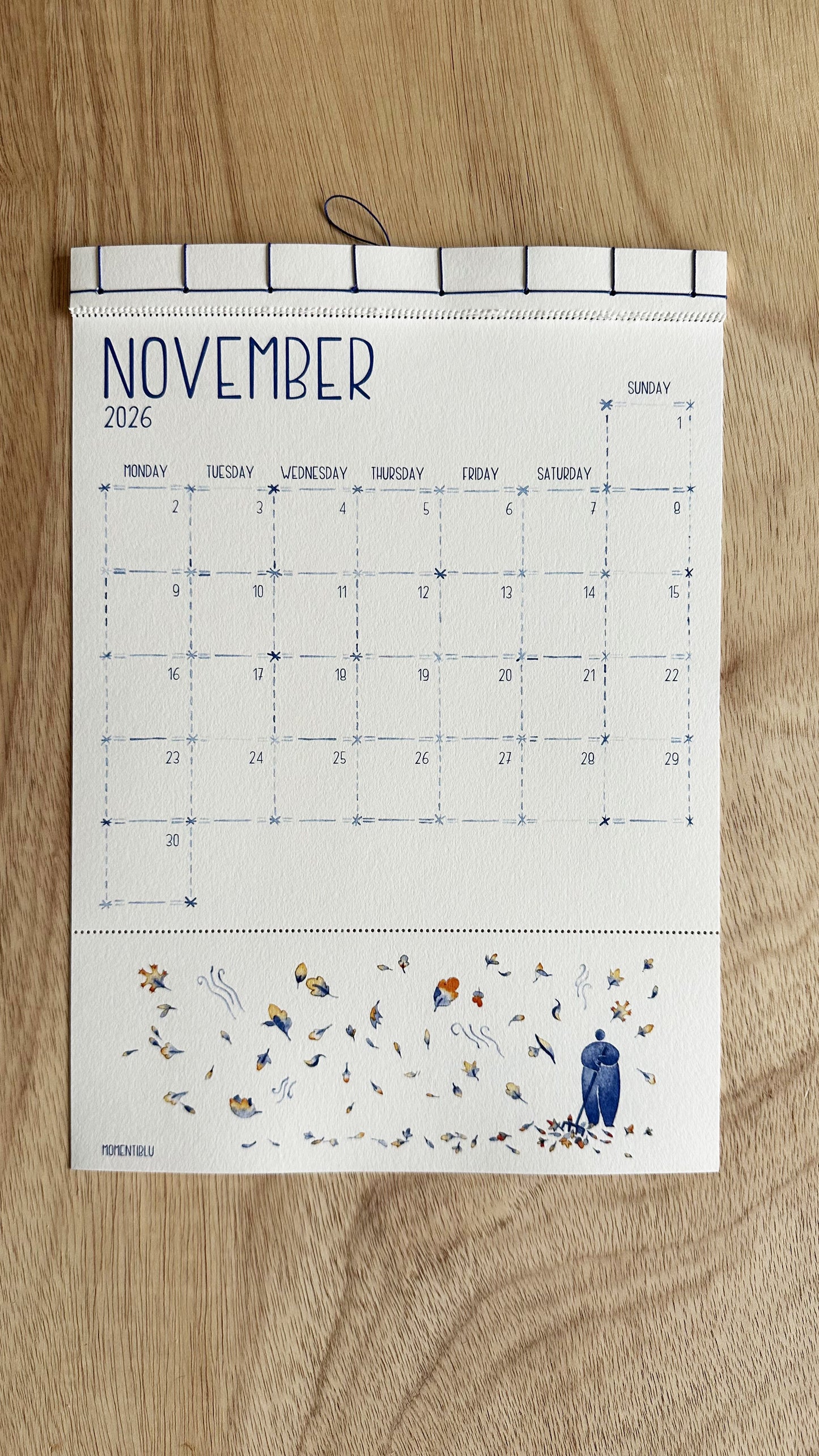 Wall calendar for November 2026 with a man in the leaves