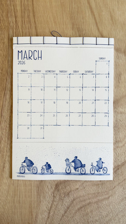 March calendar with blue illustrations of people on bicycles on a wooden surface